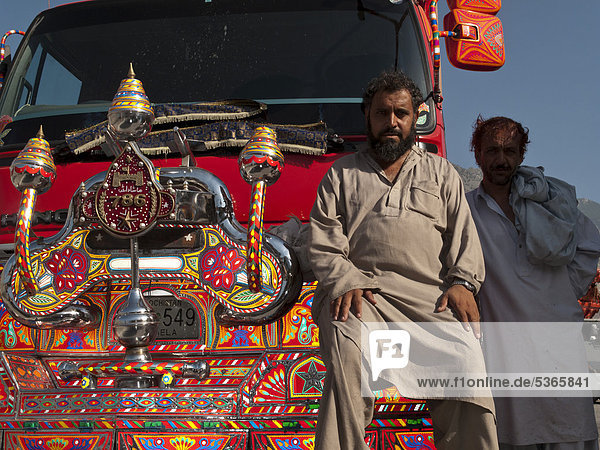 Pakistanischer LKW-Fahrer  voller Stolz auf sein bunt verziertes Fahrzeug  Gilgit  Nordwestliche Grenzprovinz  Pakistan  Südasien  Asien