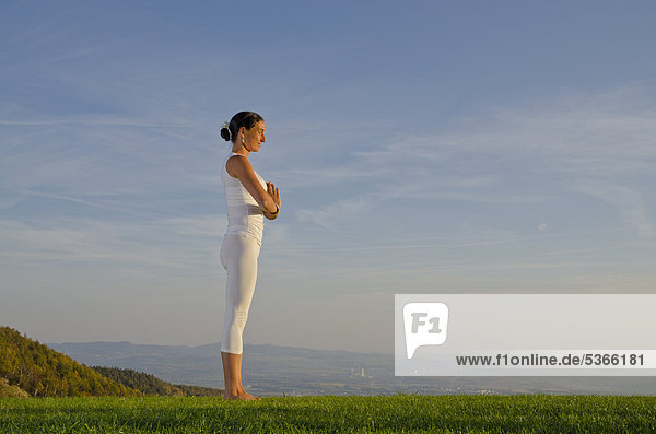 Junge Frau praktiziert Hatha-Yoga im Freien  zeigt die Stellung surya namaskar 2  Sonnengruß 2  Nove Mesto  Okres Teplice  Tschechische Republik  Europa
