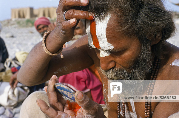 Rama Sadhu oder Heiliger Mann beim Auftragen seines Tilak oder Stirnzeichens während seines morgendlichen Puja-Rituals  Jaisalmer  Rajasthan  Indien  Asien