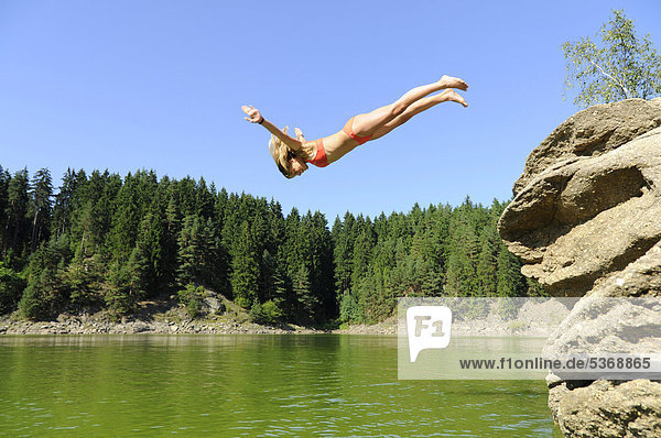 Young girl  12 years  diving off a rock  Kamp  Ottenstein reservoir  Rastenfeld  Lower Austria  Austria  Europe