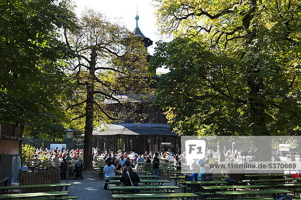 Menschen sitzen im Biergarten am Chinesischen Turm im Englischen Garten in München  Bayern  Deutschland  Europa