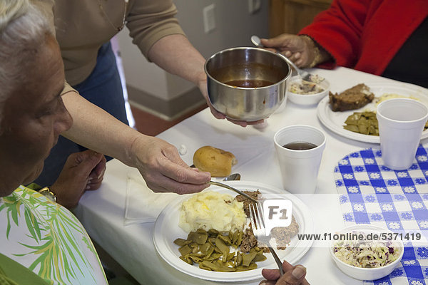 Low-income senior citizens being served lunch by members of the United Methodist Women at Asbury United Methodist Church  Knoxville  Tennessee  USA