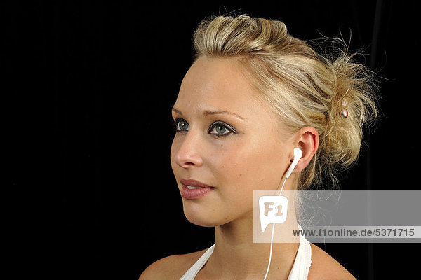 Junge Frau hört Musik mit mp3-Player  Ohrhörer  Kopfhörer  Apple iPod  iPhone