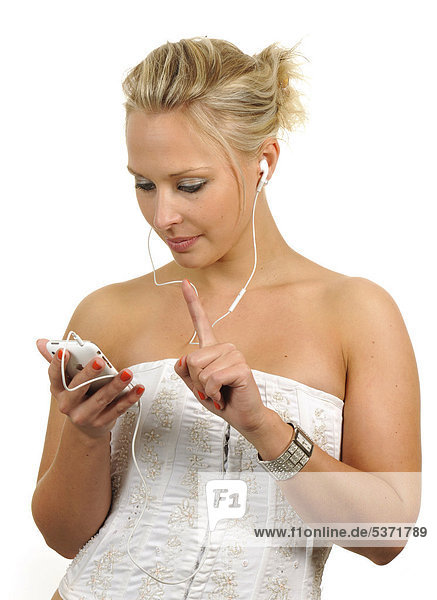 Young woman using a white Apple iPhone  listening to music with earphones