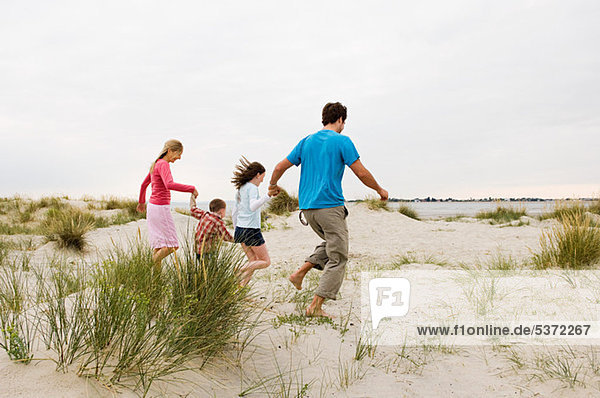 Young Family running on beach