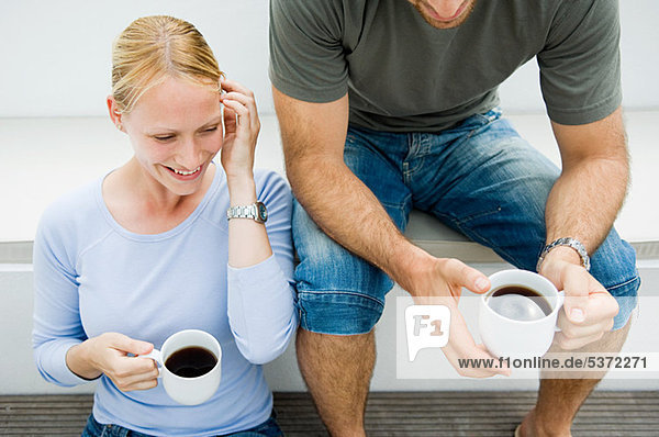 Young Couple relaxing outdoors mit Kaffee