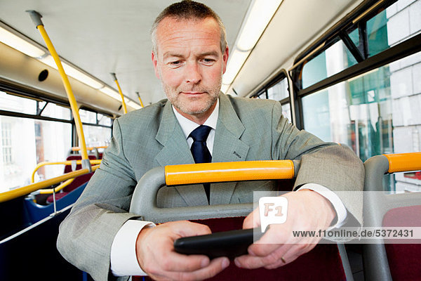 Geschäftsmann mit Smartphone im Bus