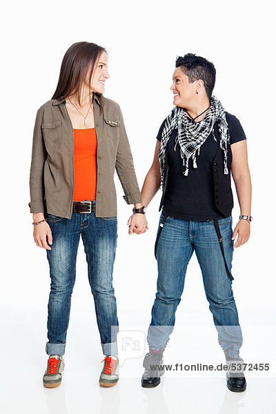 Lesbian couple holding hands against white background
