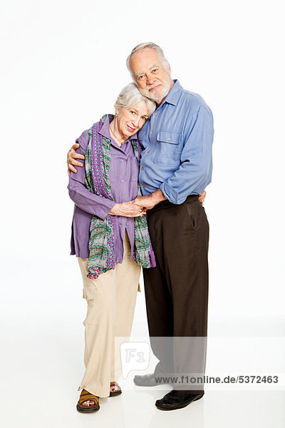 Senior Couple embracing against white background