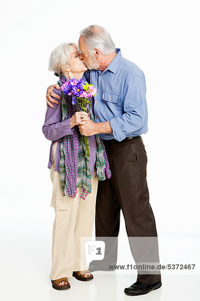 Senior Couple kissing against white background