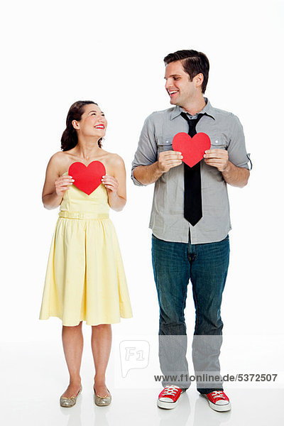 Young Couple holding Herzen Formen against white background