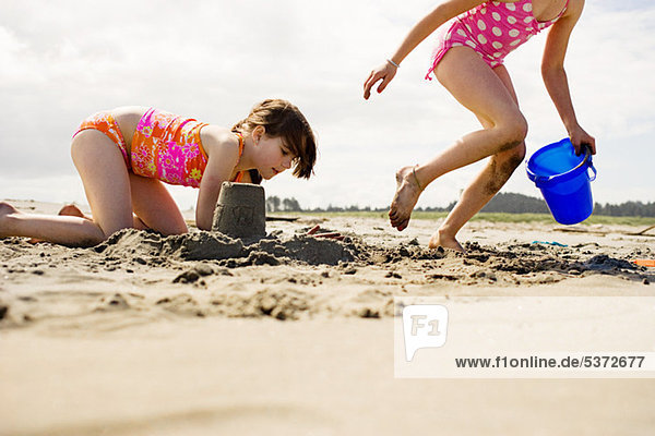 Girls making sandcastles at beach