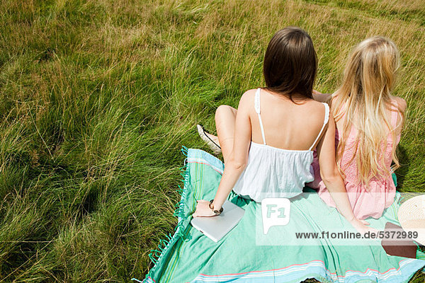 Junge Frauen sitzen zusammen in einem Feld