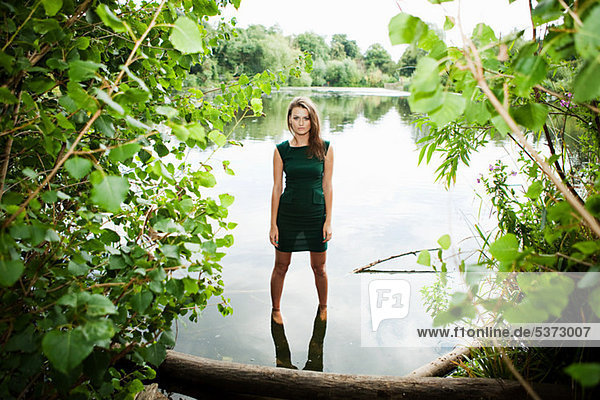 Junge Frau im grünen Kleid  in einem See