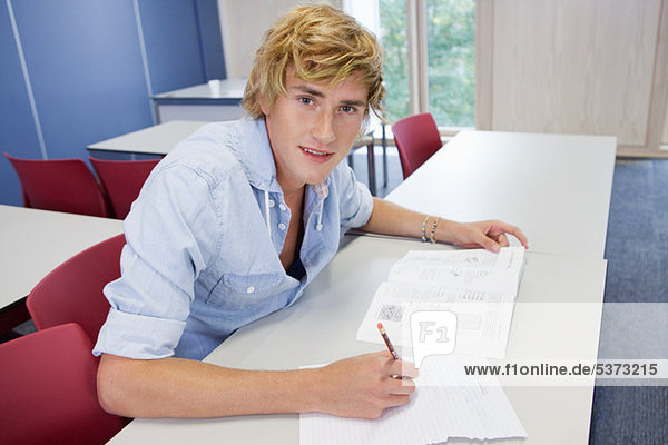 Studenten schreiben auf Prüfung Papier in Klasse