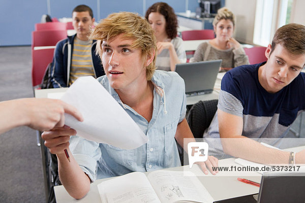 University student receiving exam paper