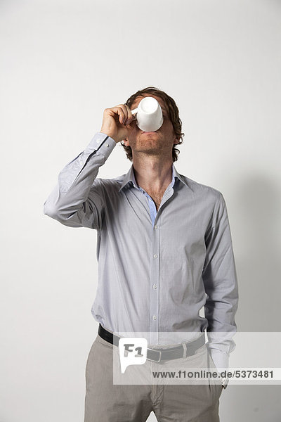 Mann trinkt Kaffee vor weißem Hintergrund