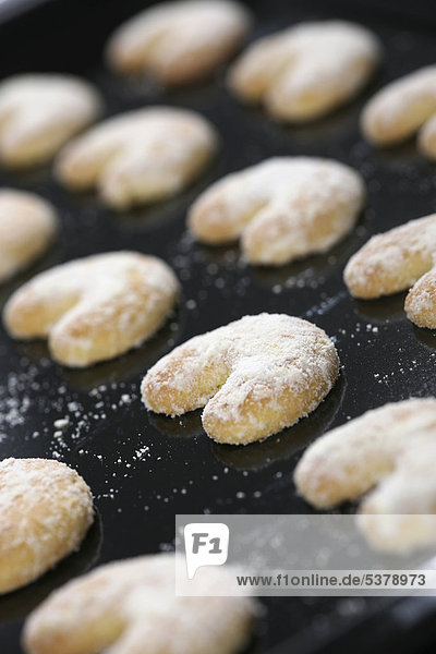 Row of vanilla crescent cookies in baking tray