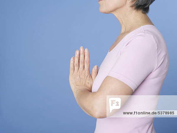 Senior woman in prayer position