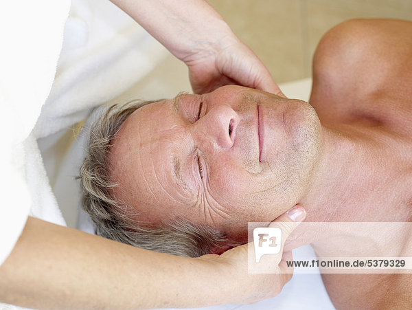 Mature man recieving massage  close up