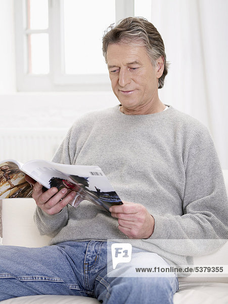 Senior man reading magazine
