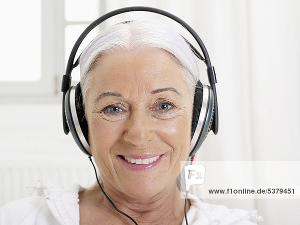 Senior woman listening music  smiling  portrait