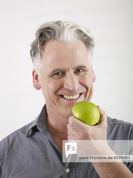 Senior Mann mit Apfel  lächelnd  Portrait
