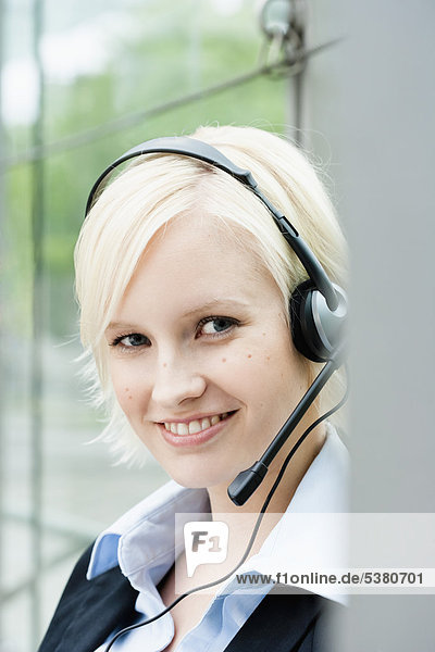 Young woman with headset  smiling  portrait