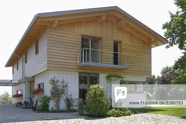 Deutschland  Oberbayern  München  Blick auf neues Holzhaus im Dorf