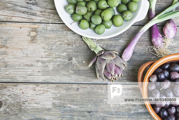 taly  Toskana  Magliano  Oliven in Schale  Frühlingszwiebeln und Artischocke auf Holztisch