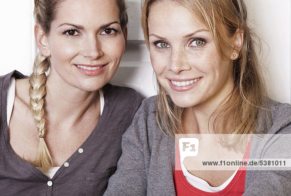 Italien  Toskana  Magliano  Zwei junge Frauen in der Küche  lächelnd  Nahaufnahme  Portrait