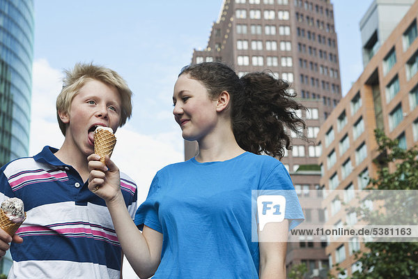 Germany  Berlin  Teenage couple eating ice cream