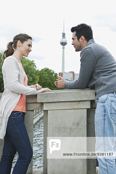 Germany  Berlin  Couple standing on bridge and talking
