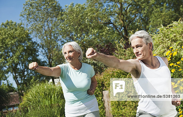 Man and woman exercising in garden  smiling