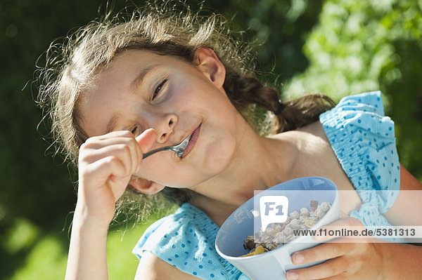 Mädchen essen Getreidefutter  lächelnd  Porträt