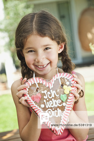Girl with gingerbread heart  smiling  portrait