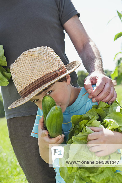 Germany  Bavaria  Grandfather with grandson in vegetable garden  smiling
