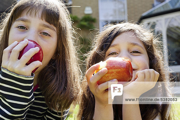 Girls eating apples outdoors
