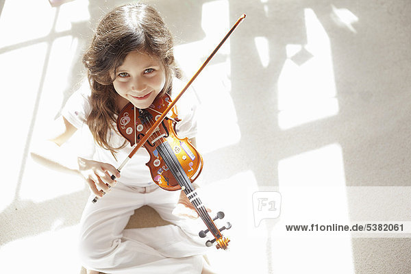 Girl playing violin on carpet