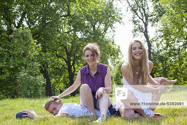 Teenagers playing in grass in park