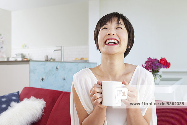 Lächelnde Frau trinkt eine Tasse Kaffee