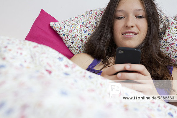 Handy  benutzen  lächeln  Bett  Mädchen