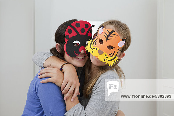 Lächelnde Mädchen mit bunten Masken