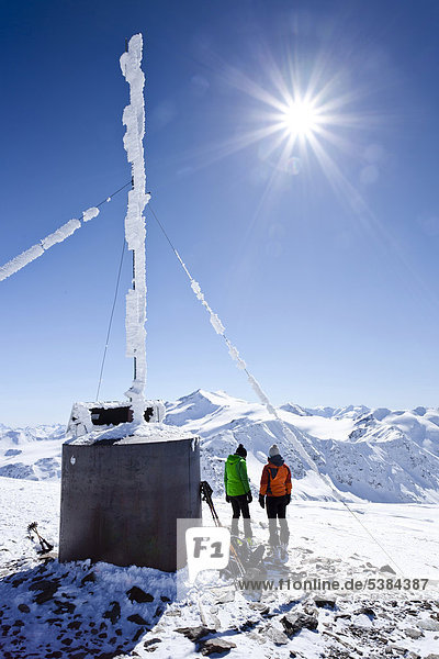 Skitourengeher auf dem Gipfel der hinteren Schöntaufspitze mit der Wetterstation  Sulden im Winter  hinten die Zufallspitze und der Cevedale  Südtirol  Italien  Europa