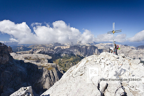 Climbers at the summit cross  Boeseekofel fixed rope route  Fanes and Heiligkreuzkofel ranges at back  Dolomites  Trentino  Italy  Europe
