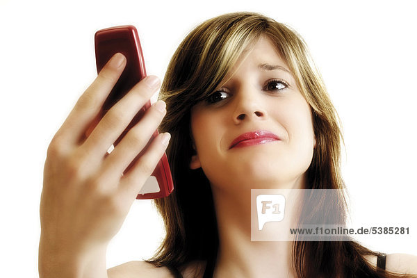 Young woman looking sceptically at her mobile phone