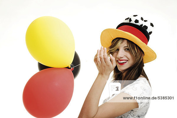 Female football fan wearing Germany hat with balloons