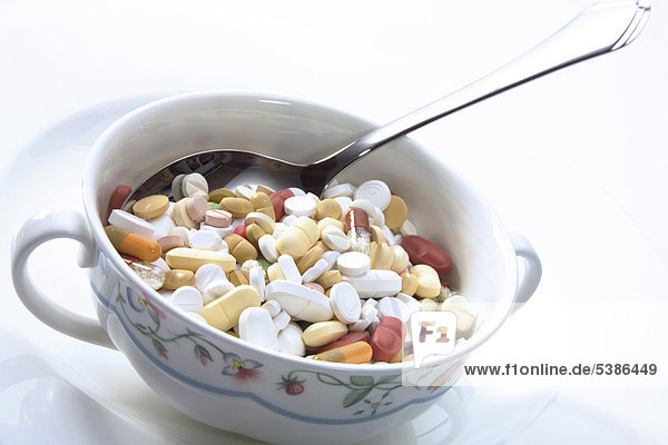 Eine Suppentasse voll Tabletten - Symbol für Diätwahn