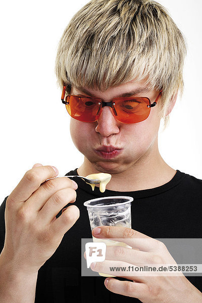 Junger Mann mit Sonnenbrille und Joghurtbecher