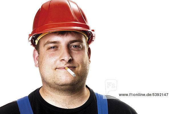 Arbeiter mit rotem Helm raucht eine Zigarette